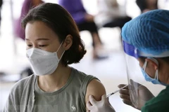 Lực lượng y tế quận Nam Từ Liêm (Hà Nội) tiêm vaccine mũi 2 cho người nước ngoài. (Ảnh: Hoàng Hiếu/TTXVN)