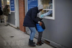 Nhân viên y tế lấy mẫu xét nghiệm COVID-19 cho trẻ em ở Brooklyn, New York (Mỹ). (Ảnh: The New York Times/TTXVN)