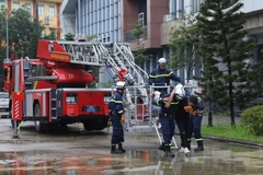 Phối hợp với lực lượng Đan Phượng, lực lượng PCCC Thành phố Hà Nội điều động xe giỏ thang đến hiện trường đưa người bị nạn từ các tầng cao ra khỏi hiện trường vụ cháy. (Ảnh: Hoàng Hiếu/TTXVN)