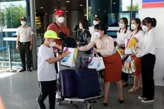 Tặng quà cho các hành khách Hàn Quốc đến sân bay quốc tế Đà Nẵng. (Ảnh: Trần Lê Lâm/TTXVN)