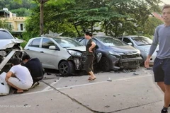 Nhiều xe ôtô đang đỗ bên đường bị đâm nát phần đầu. (Ảnh: TTXVN phát)