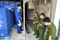 Lực lượng chức năng khai quật hệ thống mương thoát nước trong khuôn viên công ty. (Ảnh: TTXVN phát)