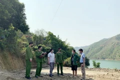 Lực lượng chức năng lập biên bản đình chỉ hoạt động của bãi tập kết cát trái phép tại xã Tạ Khoa, huyện Bắc Yên. (Ảnh: Hữu Quyết/TTXVN)