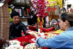 Viết câu đối tết, viết thư pháp chúc mừng năm mới luôn thu hút sự quan tâm của người đi xin chữ đầu năm mới. (Ảnh tư liệu: Hồng Nhung/TTXVN)