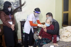 Tiêm vaccine phòng COVID-19 cho người già không thể đi lại. (Ảnh: Nguyễn Chinh/TTXVN)