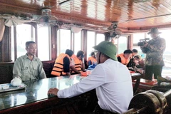 Đoàn công tác của thành phố Cẩm Phả làm việc với các hộ dân vi phạm. (Ảnh: Thanh Vân/TTXVN)