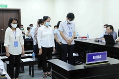 Các bị cáo nghe Viện kiểm sát công bố cáo trạng tại tòa. (Ảnh: An Đăng/TTXVN)