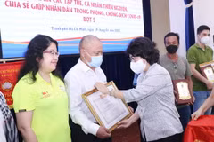 Bà Tô Thị Bích Châu, Chủ tịch Ủy ban MTTQ Việt Nam Thành phố Hồ Chí Minh trao Giấy Biểu dương và biểu trưng tri ân các tổ chức thiện nguyện. (Ảnh: Xuân Khu/TTXVN)