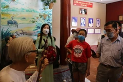 Du khách tìm hiểu về thân thế nhạc sỹ Cao Văn Lầu - người sáng tác bản Dạ cổ hoài lang nổi tiếng. (Ảnh: Tuấn Kiệt/TTXVN)