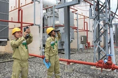 Công nhân Công ty Truyền tải Điện kiểm tra, vận hành trạm biến áp 500kV. (Ảnh: Ngọc Hà/TTXVN)