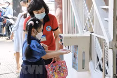 Học sinh trường tiểu học Hòa Bình, quận 1, được giáo viên hướng dẫn rửa tay trước khi vào lớp. (Ảnh: Hồng Giang/TTXVN)
