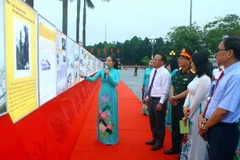 Các đại biểu xem các bức ảnh tại Triển lãm “Đẩy mạnh học tập và làm theo tư tưởng, đạo đức, phong cách Hồ Chí Minh.” (Ảnh: Tá Chuyên/TTXVN)