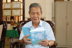 Ông Phạm Thanh Phong xem lại cuốn hồi ký khi vào Chiến khu Cách mạng. (Ảnh: Thanh Bình/TTXVN)