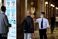 Kiểm tra thân nhiệt trước khi vào một trung tâm thương mại. (Ảnh minh họa: AFP/TTXVN)