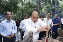 Chủ tịch nước Nguyễn Xuân Phúc cùng đoàn công tác dâng hương tưởng nhớ Chủ tịch Hồ Chí Minh tại Lán Nà Nưa trong Khu di tích lịch sử Quốc gia đặc biệt Tân Trào. (Ảnh: Thống Nhất/TTXVN)