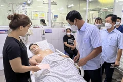 Ông Hồ Đại Dũng, Phó Chủ tịch UBND tỉnh Phú Thọ thăm hỏi, động viên gia đình người gặp nạn đang được cấp cứu tại bệnh viện. (Ảnh: Trung Kiên/TTXVN)