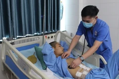 Bác sỹ Chuyên khoa I Phạm Văn Khang, Khoa Hồi sức Tích cực Chống độc, Bệnh viện Trung ương Thái Nguyên kiểm tra sức khỏe cho bệnh nhân TVD sau khi hồi phục. (Ảnh: TTXVN phát)