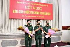 Đại tướng Lương Cường, Ủy viên Bộ Chính trị, Chủ nhiệm Tổng Cục Chính trị Quân đội Nhân dân Việt Nam tặng hoa chúc mừng Thiếu tướng Nguyễn Văn Gấu và Thiếu tướng Hồ Văn Thái. (Ảnh: TTXVN phát)