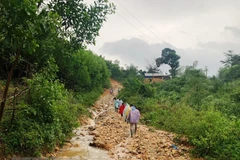 Đường liên thôn bị hư hỏng nghiêm trọng do mưa lũ. (Ảnh: TTXVN phát)
