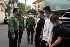 Đại tá Nguyễn Quốc Hùng, Giám đốc Công an tỉnh Hà Nam cùng các đối tượng. (Ảnh: TTXVN phát)