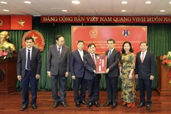 Đoàn đại biểu Viện Kiểm sát Nhân dân Tối cao Lào trao quà lưu niệm hữu nghị cho Viện Kiểm sát Nhân dân Thành phố Hồ Chí Minh tại buổi làm việc. (Ảnh: Hồng Giang/TTXVN)