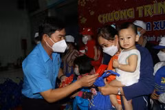 Phó Chủ tịch Liên đoàn Lao động TP Hồ Chí Minh Phạm Chí Tâm thăm hỏi, chúc Tết tặng quà cho công nhân lao động về quê đón Tết trên "Chuyến tàu mùa Xuân." (Ảnh: Thanh Vũ/TTXVN)