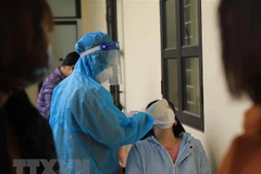 Nhân viên Trạm y tế lưu động lấy mẫu xét nghiệm sàng lọc cho người dân. (Ảnh: Hoàng Hiếu/TTXVN)