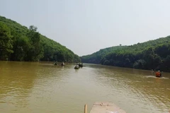 Lực lượng chức năng dùng thuyền tổ chức tìm kiếm anh H. trên đập Khe Nậy. (Nguồn: laodong.vn)