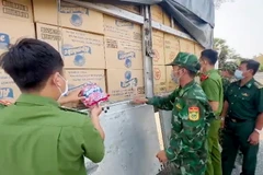 Lực lượng chức năng kiểm đếm số hàng hóa không rõ nguồn gốc vừa bắt giữ. (Ảnh: TTXVN phát)