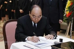 Chủ tịch nước Nguyễn Xuân Phúc ghi sổ tang tưởng niệm cố Thủ tướng Nhật Bản Abe Shinzo. (Ảnh: Thống Nhất/TTXVN)