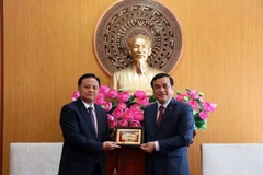 Ủy viên Trung ương Đảng Nhân dân Cách mạng Lào, Bí thư, Tỉnh trưởng tỉnh Savannakhet Xẳntịphạp Phômvihản tặng quà cho Bí thư Tỉnh ủy tỉnh Quảng Nam Phan Việt Cường. (Ảnh: Trần Tĩnh/TTXVN)