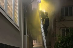 Lực lượng Cảnh sát phòng chống chữa cháy và cứu hộ cứu nạn Công an quận Hai Bà Trưng triển khai cứu người mắc kẹt trong đám cháy. (Ảnh: TTXVN phát)