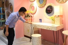 Khách tham quan các sản phẩm thủ công mỹ nghệ tại triển lãm. (Ảnh: Xuân Anh/TTXVN)