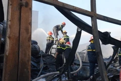 Lực lượng chức năng đã cơ bản khống chế ngọn lửa. (Ảnh: Quốc Dũng/TTXVN)