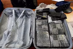 Cơ quan chức năng thu giữ số lượng lớn tiền mệnh giá 100 USD bị nhuộm đen bằng hóa chất. (Ảnh: TTXVN phát)