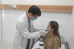 Bác sỹ Bệnh viện Da liễu Thành phố Hồ Chí Minh thăm khám cho một bệnh nhân biến chứng sau khi tiêm chất làm đầy tại spa. (Ảnh: TTXVN phát)