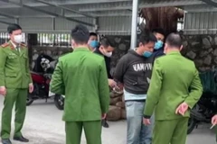 Đối tượng Trần Quang Minh (áo đen) bị bắt tại hiện trường. (Ảnh: TTXVN phát)