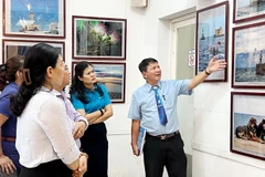 Nghệ sỹ nhiếp ảnh Đoàn Hoài Trung, Chủ tịch Hội Nhiếp ảnh Thành phố Hồ Chí Minh giới thiệu các tác phẩm tại triển lãm. (Ảnh: Thu Hương/TTXVN)