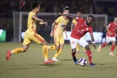 Một pha tranh bóng giữa các cầu thủ đội bóng đá Thành phố Hồ Chí Minh-áo đỏ, với đội bóng đá Thanh Hóa-áo vàng. (Ảnh: Thanh Vũ/TTXVN)