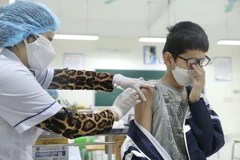 Nhân viên y tế tiêm vaccine phòng COVID-19 cho học sinh. (Ảnh: Minh Quyết/TTXVN)