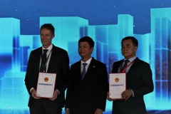 Chủ tịch UBND tỉnh Bình Dương Võ Văn Minh trao Giấy chứng nhận đầu tư cho đại diện Tập đoàn LEGO và chủ đầu tư Khu công nghiệp VSIP3. (Ảnh: Chí Tưởng/TTXVN)