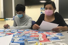Các đối tượng được triệp tập tại đồn công an cùng với số lượng thuốc được cho là điều trị COVID-19 không rõ nguồn gốc, chứng từ. (Ảnh: PV/Vietnam+)