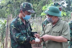 Bí thư Tỉnh ủy Bình Phước Nguyễn Văn Lợi thăm hỏi chiến sỹ biên phòng bị thương khi làm nhiệm vụ tại chốt số 4, Đồn Biên phòng Lộc Tấn. (Ảnh: Sỹ Tuyên/TTXVN)