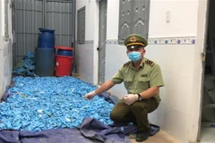 Hàng nghìn găng tay y tế được tái chế chuẩn bị bán ra thị trường. (Ảnh: TTXVN)