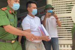 Lực lượng công an áp giải ông Tùng sau khi đọc lệnh bắt giữ. (Ảnh: TTXVN phát)