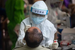 Nhân viên y tế lấy mẫu dịch xét nghiệm COVID-19 cho người dân tại Jakarta, Indonesia. (Ảnh: THX/TTXVN)