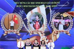 Chủ tịch UBND thành phố Hà Nội tặng bằng khen cho các học sinh xuất sắc, có nhiều thành tích. (Ảnh: Thanh Tùng/TTXVN)