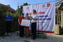 Trao hỗ trợ xây nhà cho bà Phạm Thị Gái. (Ảnh: Mai Trang/TTXVN)