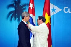 Bộ trưởng Ngoại giao Cuba trao tặng Huy chương Hữu nghị cho Đại sứ Dương Minh. (Ảnh: Lê Hà/TTXVN)
