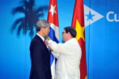 Bộ trưởng Ngoại giao Cuba trao tặng Huy chương Hữu nghị cho Đại sứ Dương Minh. (Ảnh: Lê Hà/TTXVN)